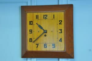 a vintage french art deco styled wooden wind up wall clock