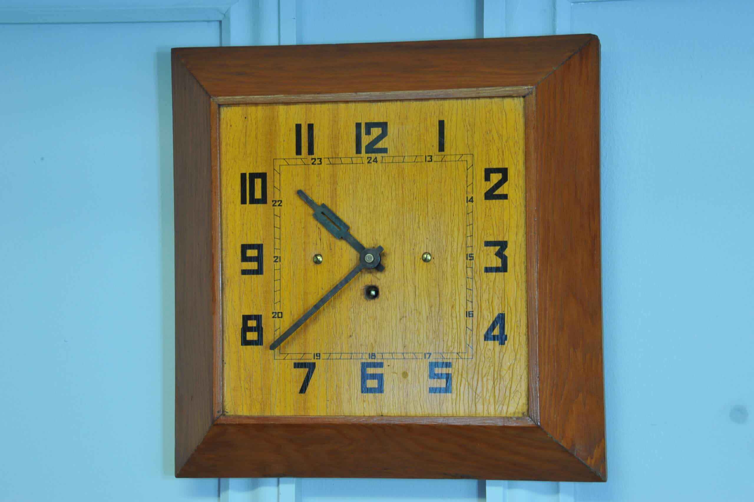 a vintage french art deco styled wooden wind up wall clock