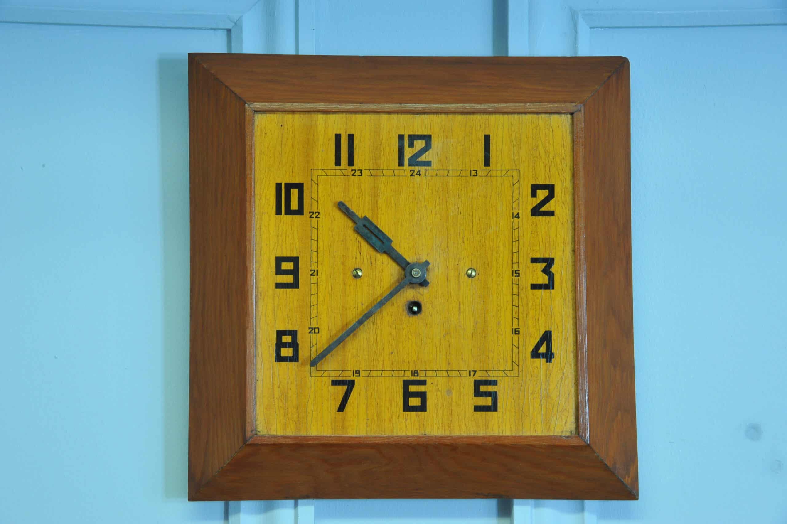 a vintage french art deco styled wooden wind up wall clock