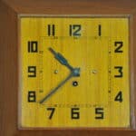 a vintage french art deco styled wooden wind up wall clock