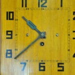 a vintage french art deco styled wooden wind up wall clock