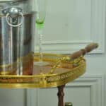 a vintage two tier brass and inlaid wood bar cart drinks trolley
