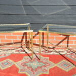 Pair of mid-century French maison jansen brass and glass side tables with stretcher and ball finial, circa 1950's, front view