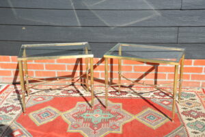 Pair of mid-century French maison jansen brass and glass side tables with stretcher and ball finial, circa 1950's, front view