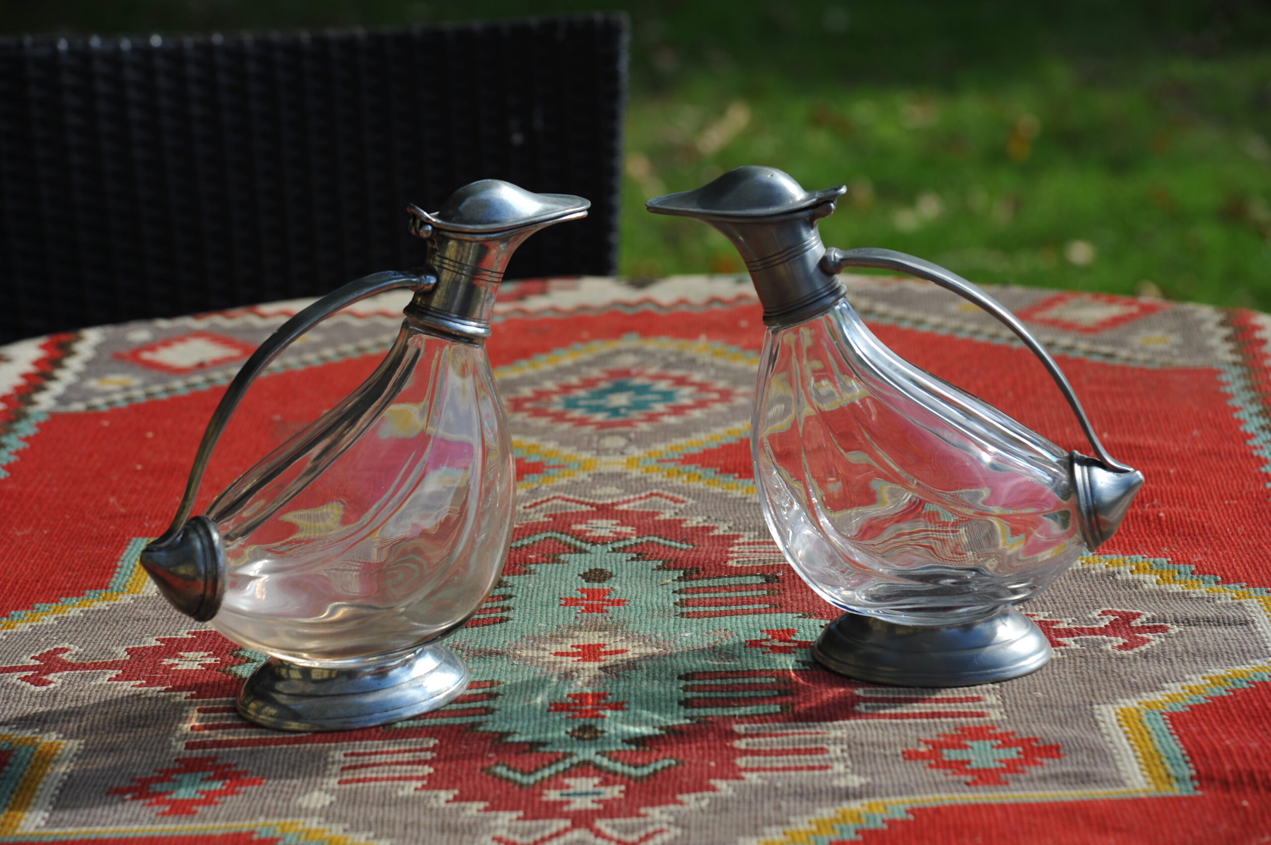 Pair of vintage French glass duck-shaped decanters with pewter mounts and hinged lids.