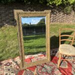 Large 19th-century French guilt gesso wall mirror with ornate scrolling frame and bevelled glass plate, front view