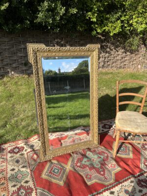 Large 19th-century French guilt gesso wall mirror with ornate scrolling frame and bevelled glass plate, front view
