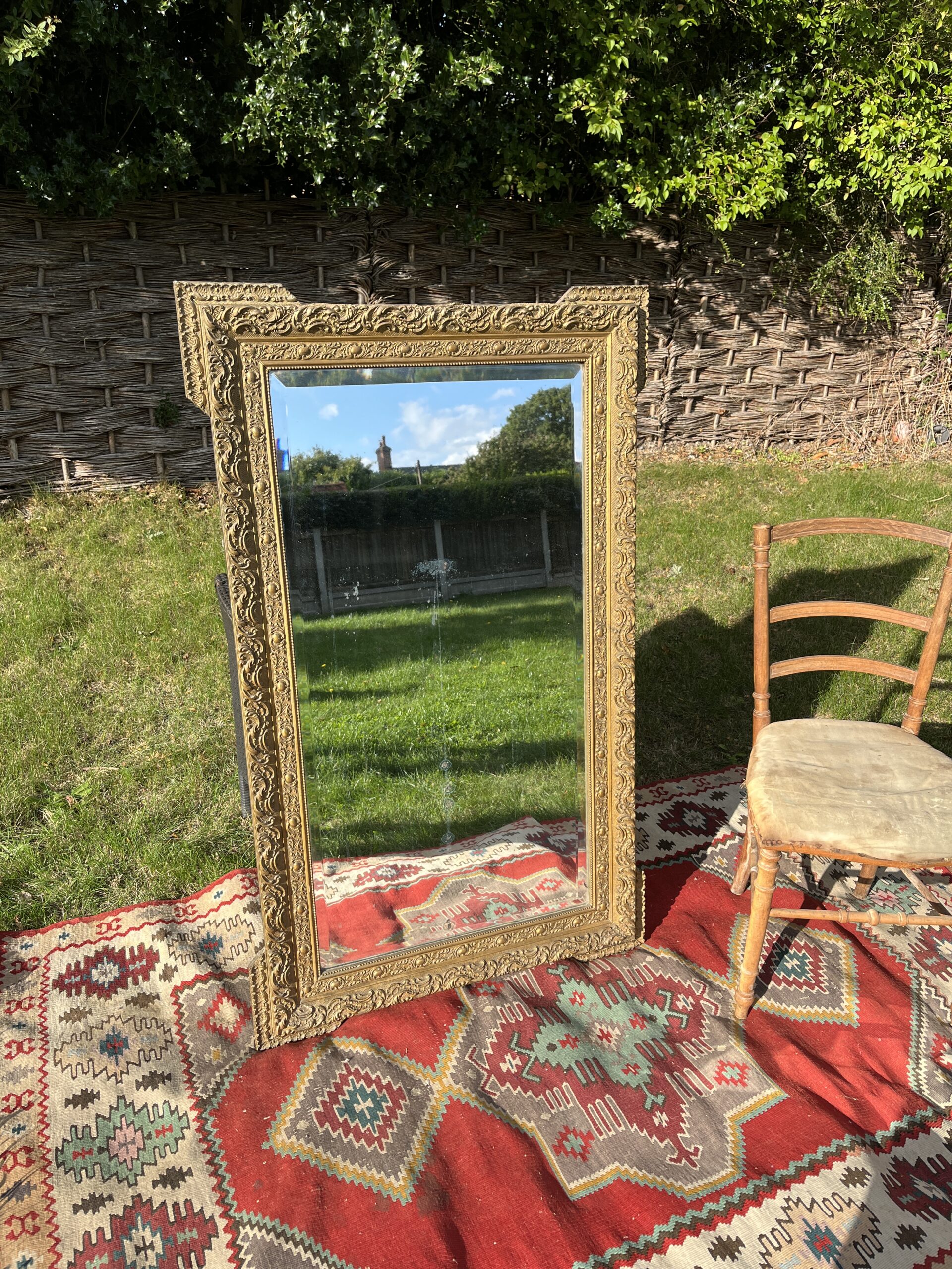 Large 19th-century French guilt gesso wall mirror with ornate scrolling frame and bevelled glass plate, front view