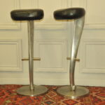 a pair of mid c swivel bar stools in solid pewter