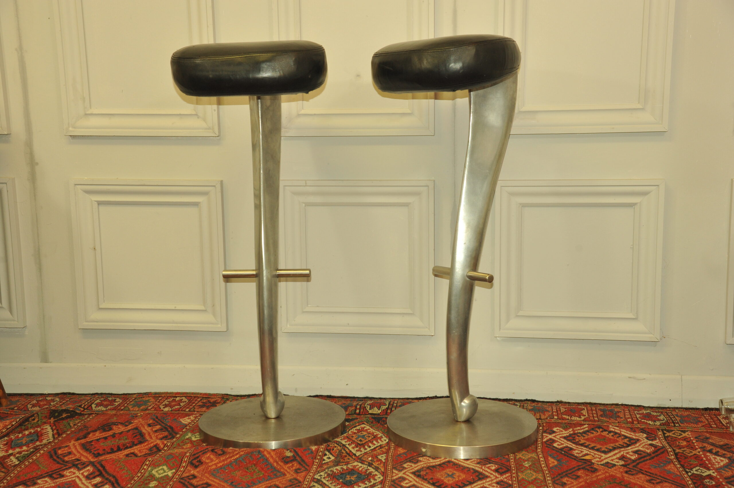 a pair of mid c swivel bar stools in solid pewter