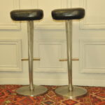 a pair of mid c swivel bar stools in solid pewter