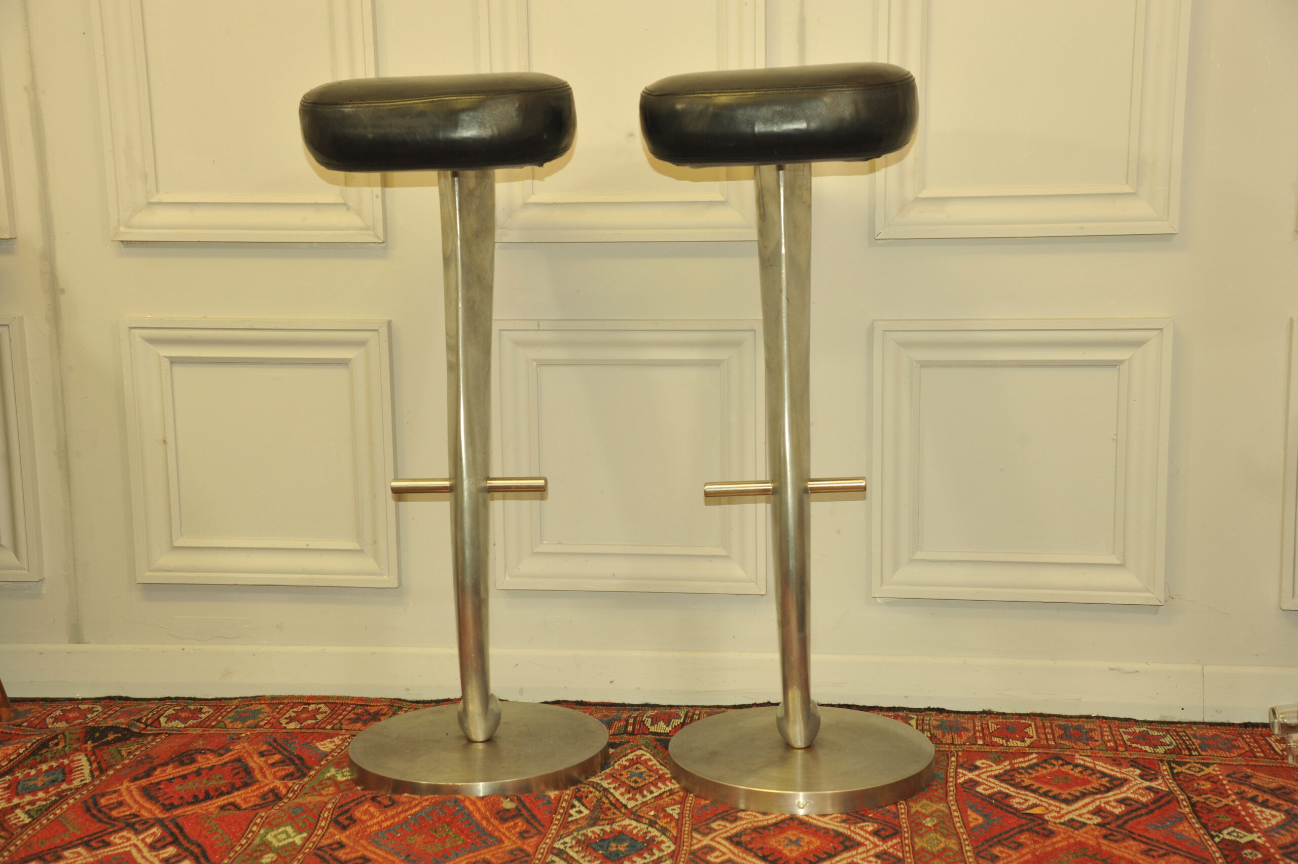 a pair of mid c swivel bar stools in solid pewter