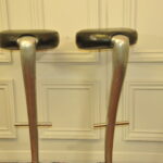 a pair of mid c swivel bar stools in solid pewter